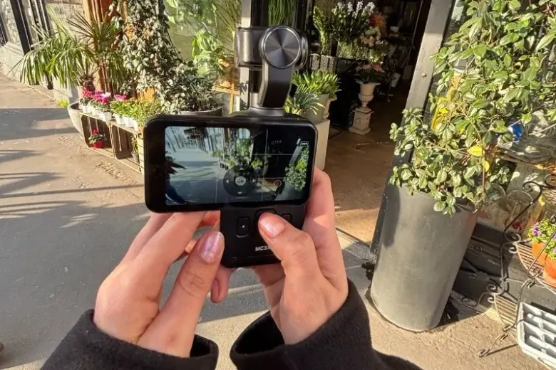 Kamera AgfaPhoto Realimove MC3X z gimbalem i poziomym ekranem trzymana w dłoniach