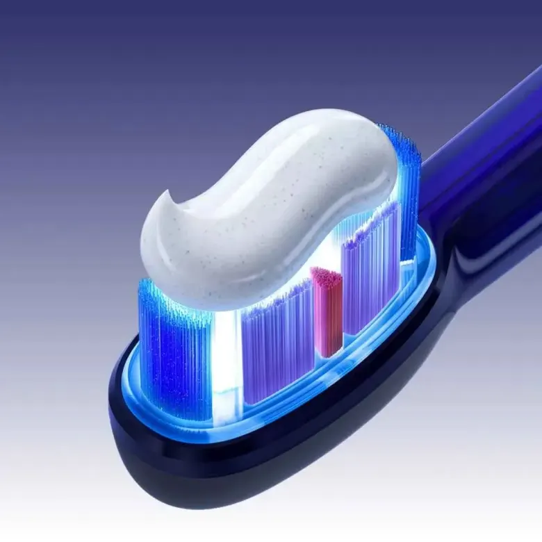 Główka szczoteczki bixdo Glossonic Brush AIR podświetlona niebieskim światłem, z pastą na włosiu