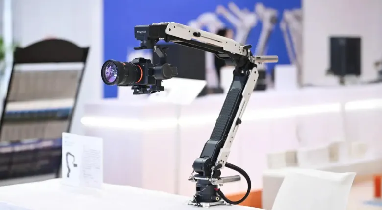 Ramię robotyczne Cilin X z aparatem bezlusterkowym na stole wystawowym