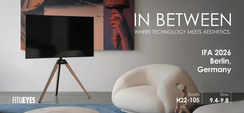 Grafika FITUEYES In Between z telewizorem na trójnożnym stojaku obok białego fotela, z numerem stoiska H22-105 na IFA 2026