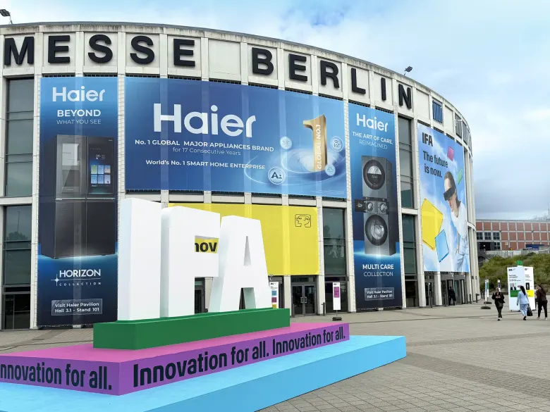 Budynek Messe Berlin z dużymi banerami Haier i rzeźbą z napisem IFA przed wejściem