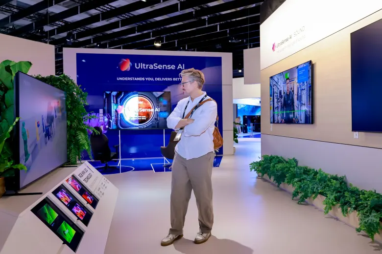 Mężczyzna przed ekspozycją telewizorów Haier z napisem UltraSense AI na stoisku na IFA 2026
