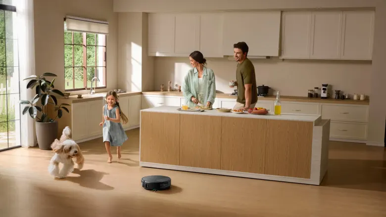 Robot odkurzający z mopem iRobot Roomba Max 875 Combo w kuchni, w tle rodzina i pies