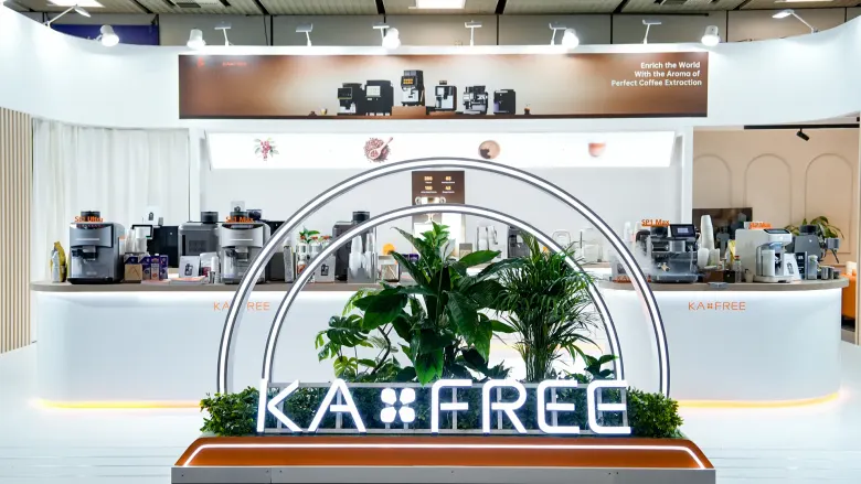 Stoisko KAXFREE na IFA 2026 z podświetlonym logo i ekspresami do kawy na ladzie