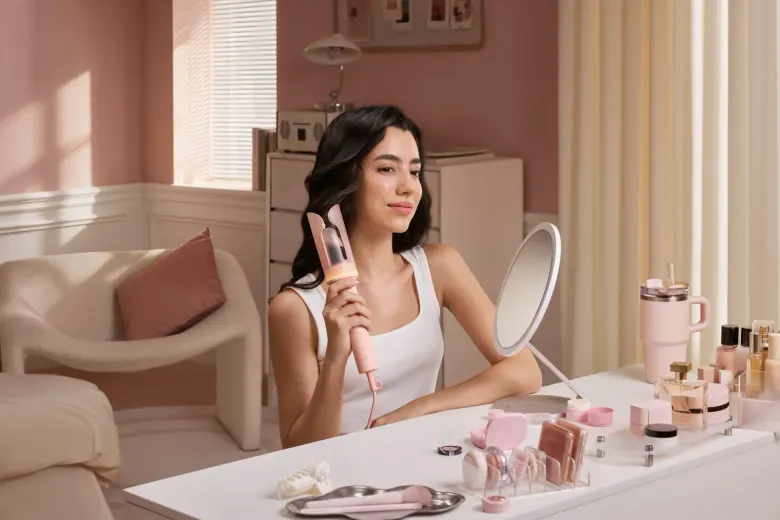 Kobieta kręci włosy różową lokówką Laifen AutoCurl przed lustrem Laifen Glowy