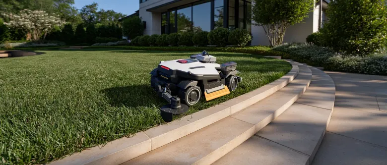 Robot koszący MAMMOTION LUBA 4 AWD z przystawką do krawędzi przycina trawę przy kamiennych schodach