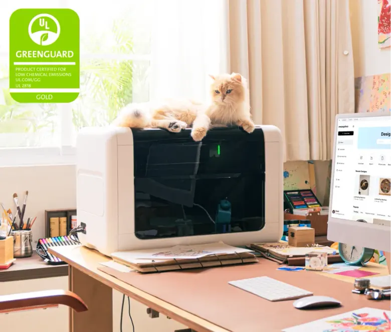 Drukarka UV Morpho na biurku w domowej pracowni, obok monitor z aplikacją do projektów