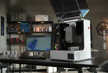 Biurkowa frezarka CNC NestWorks C500 z otwartą pokrywą w warsztacie, obok monitor z programem NestStudio