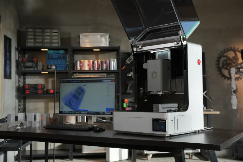 Biurkowa frezarka CNC NestWorks C500 z otwartą pokrywą w warsztacie, obok monitor z programem NestStudio