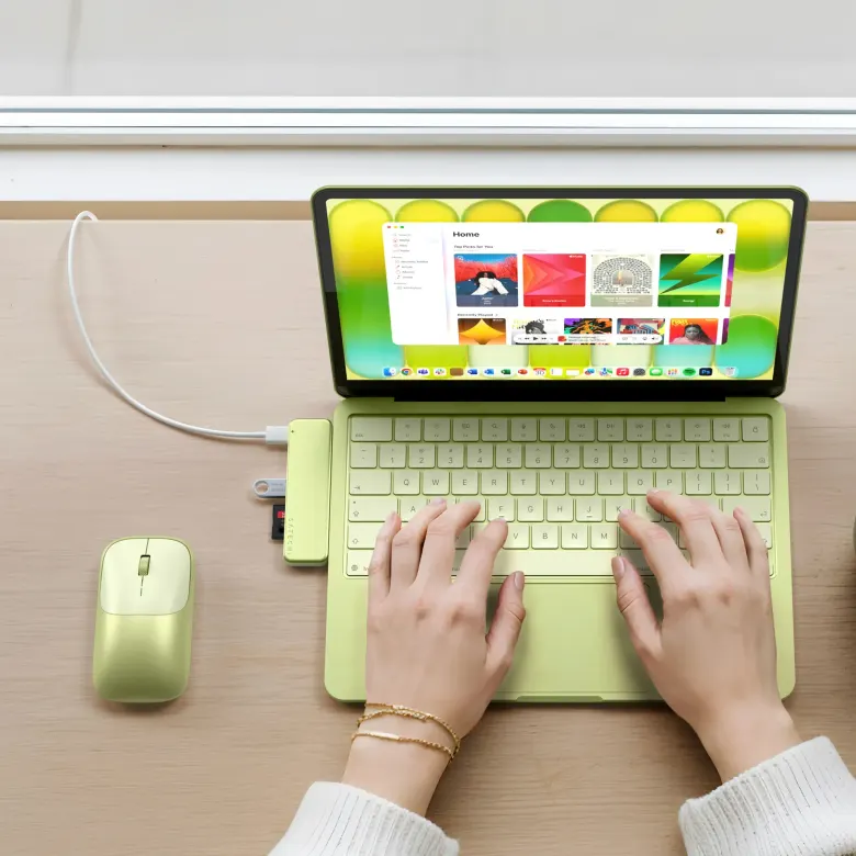 Hub Satechi USB-C Snap Hub w kolorze Citrus podłączony do MacBooka Neo, obok mysz Slim EX