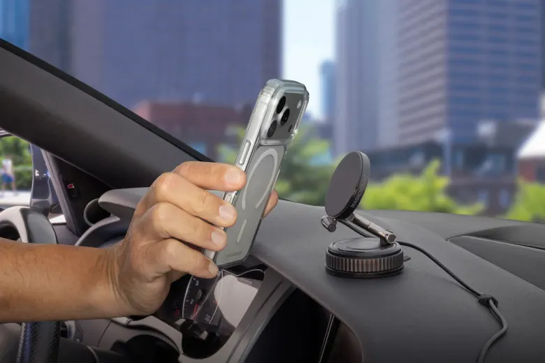 Kierowca przykłada iPhone'a do magnetycznego uchwytu samochodowego z ładowaniem indukcyjnym Scosche MagicMount Charge Pro na desce rozdzielczej