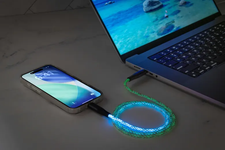Kabel Scosche GloBright świecący na niebiesko i zielono podłączony do telefonu i laptopa