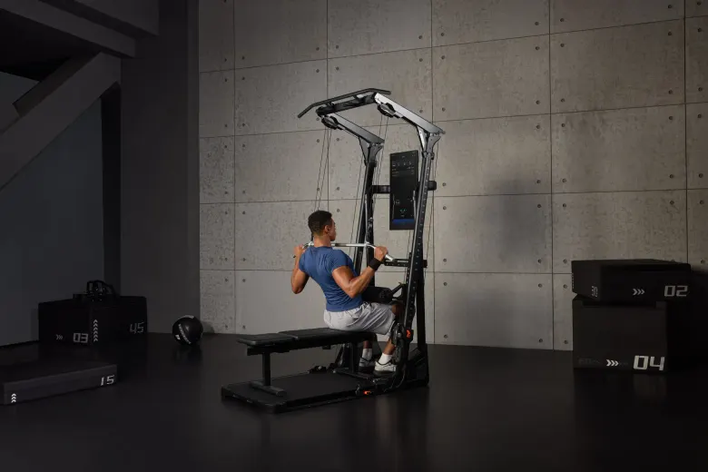 Mężczyzna ćwiczy na wyciągu górnym Speediance Gym Monster Ultra