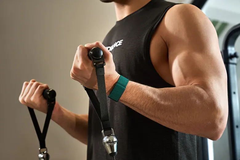 Zielona opaska Speediance Strap na nadgarstku podczas ćwiczeń z linką