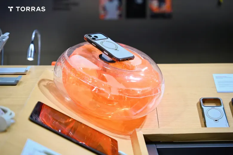 iPhone w etui TORRAS Ostand Q3 Air Pro na przezroczystej, pomarańczowej poduszce powietrznej na ekspozycji