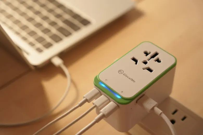 Adapter podróżny GlocalMe RoamPlug w gniazdku ładuje laptopa i inne urządzenia przez porty USB-C