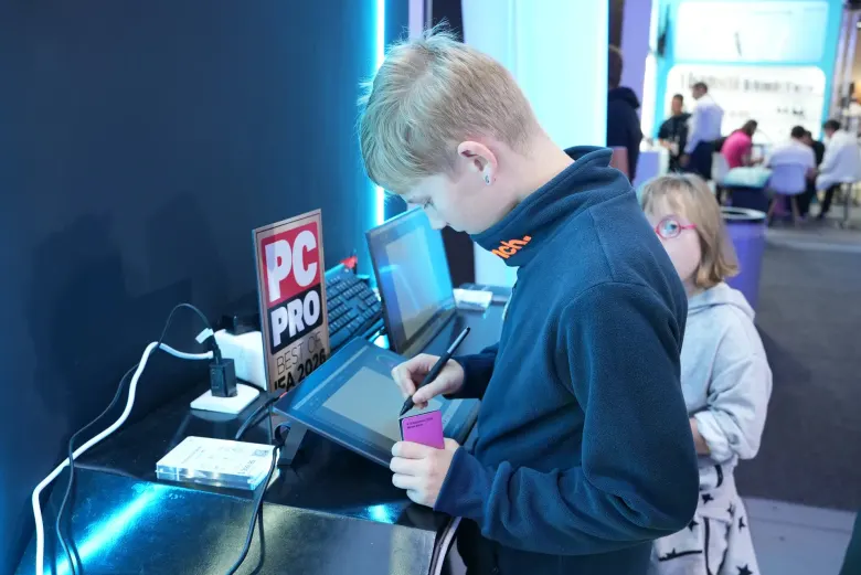 Młody zwiedzający rysuje piórem na ekranie graficznym UPERFECT UD14BQ