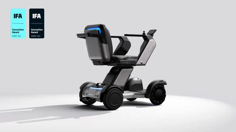 Srebrny autonomiczny robot do poruszania się Xcanbot Mate X z fotelem i podłokietnikami na jasnym tle, z odznakami IFA Innovation Award